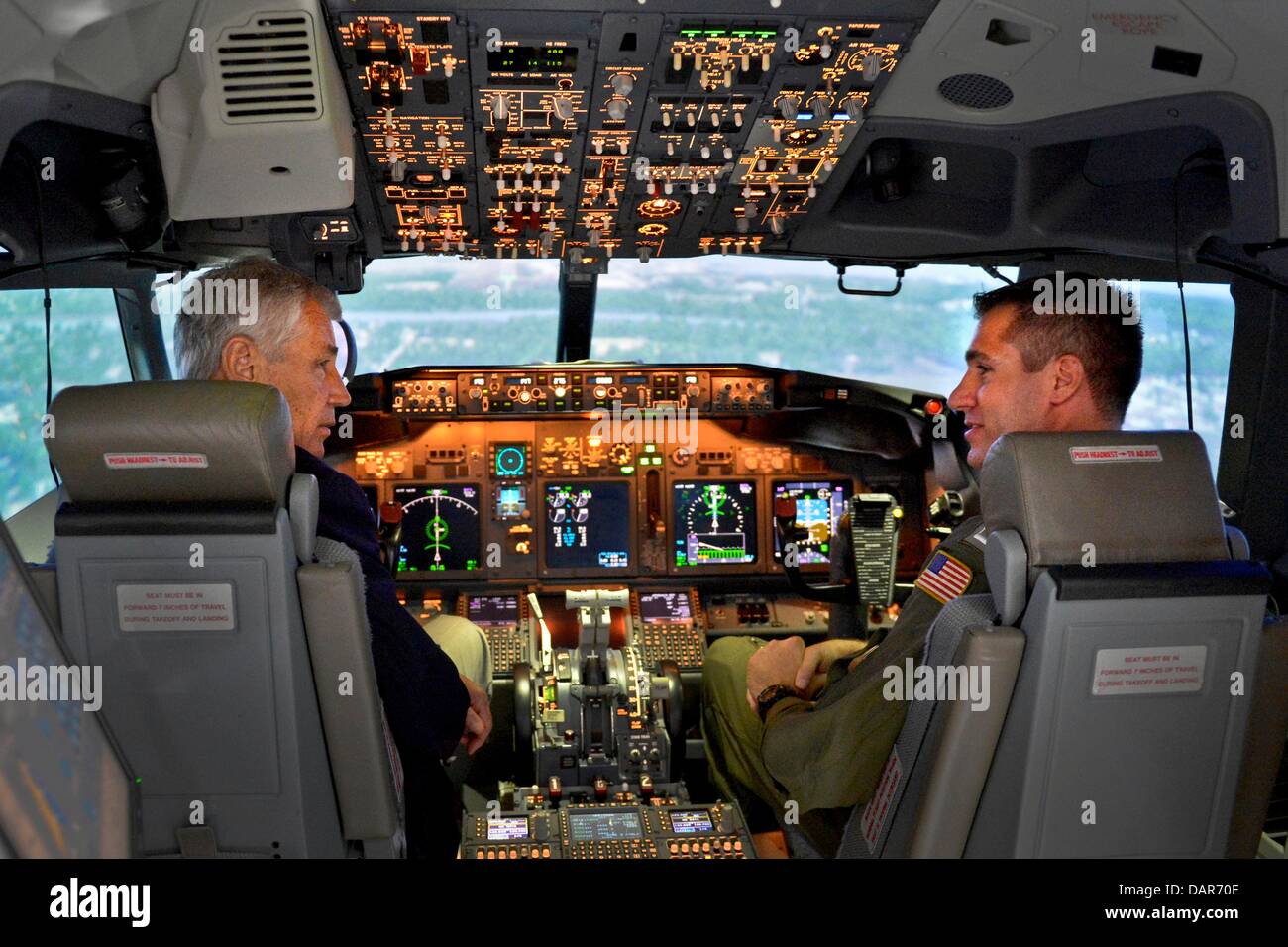 Le secrétaire américain à la défense Chuck Hagel, à gauche, est assis dans le cockpit d'un simulateur de vol de l'aéronef P-8 alors qu'il visite le VP-30 centre de formation au Naval Air Station Jacksonville, 16 juillet 2013 à Jacksonville, FL. Banque D'Images