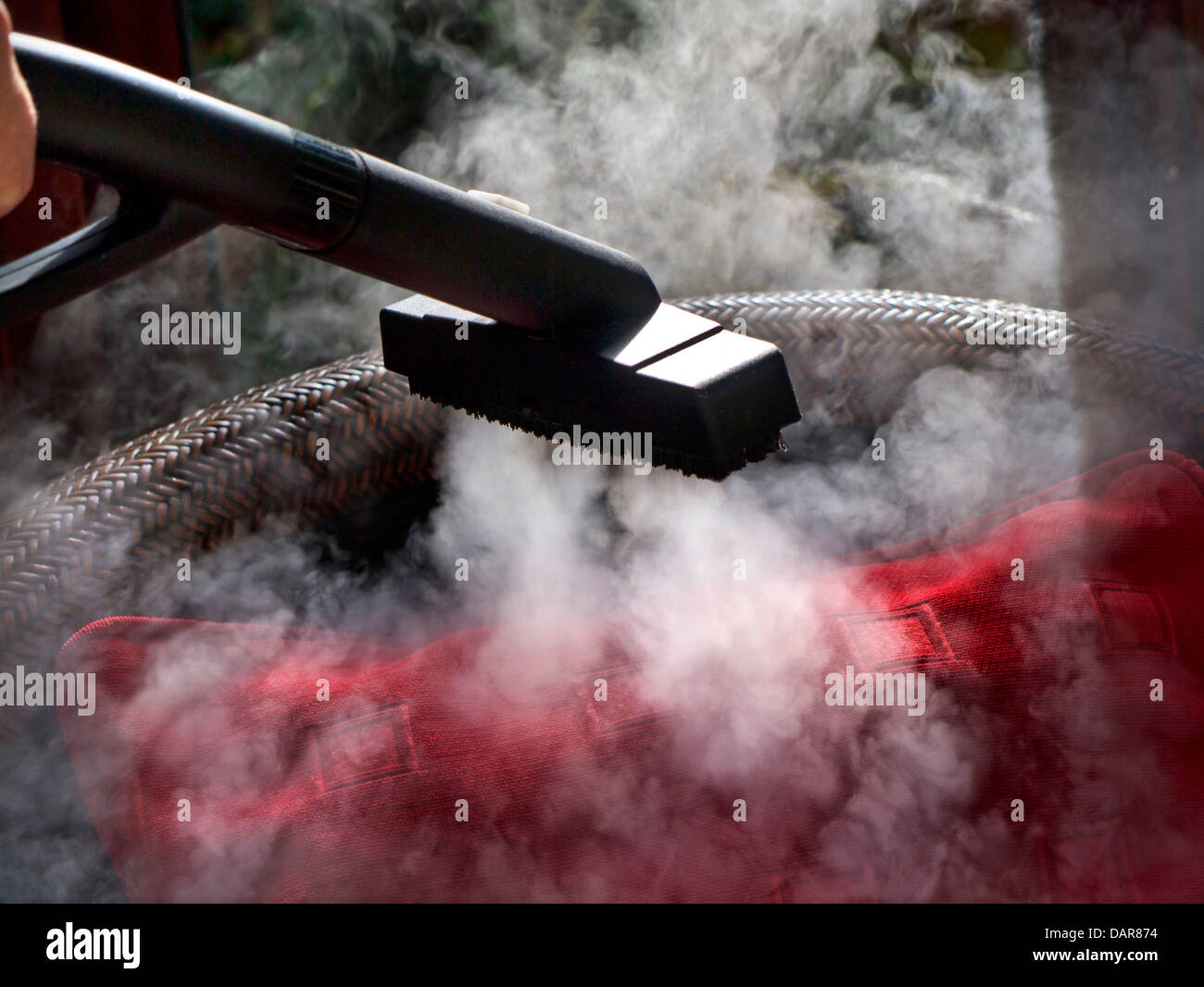 NETTOYAGE À LA VAPEUR DU CORONAVIRUS COVID-19 TISSU DOMESTIQUE antiviral nettoyage à la vapeur dans un jardin d'hiver ensoleillé Banque D'Images