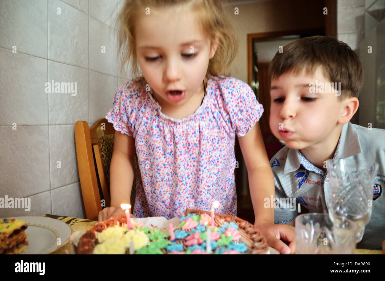 Kids blowing out candles on cake, Ukraine Banque D'Images