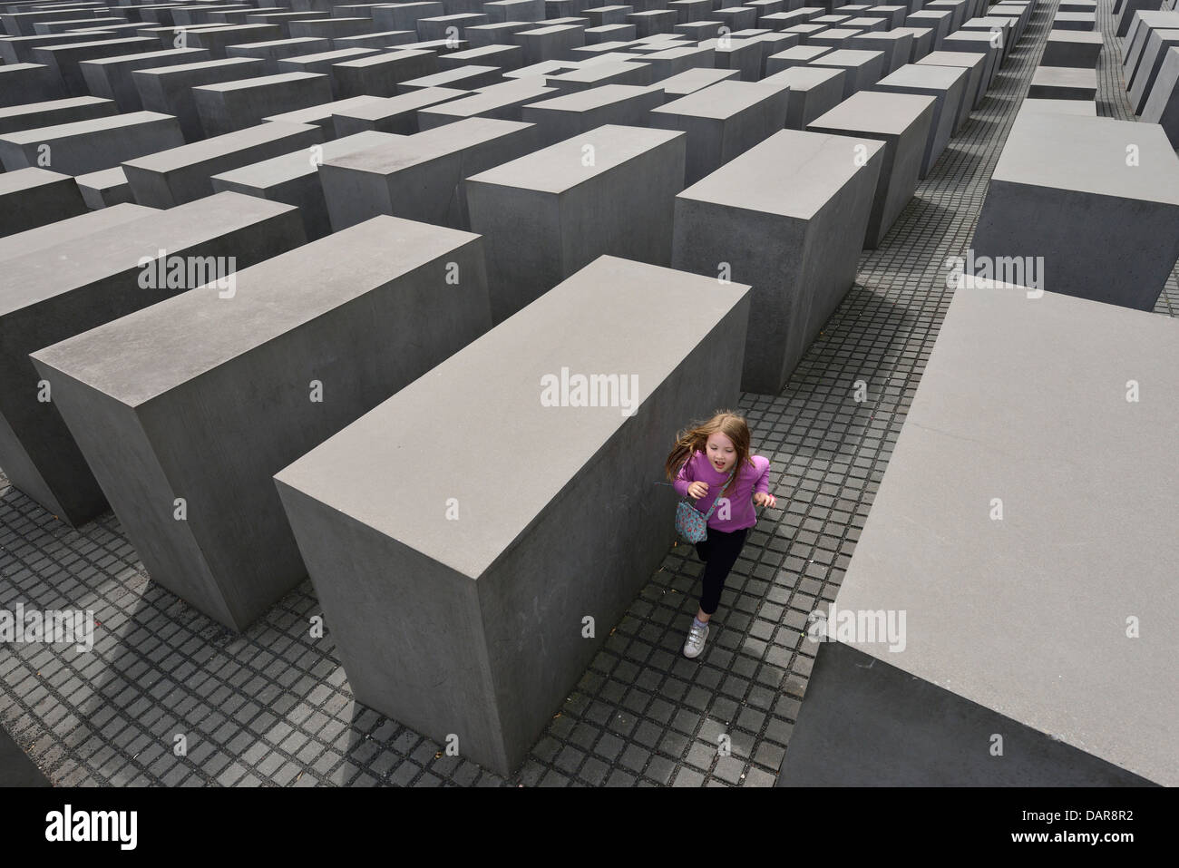 Berlin. L'Allemagne. Mémorial aux Juifs assassinés d'Europe / Holocaust Memorial, un enfant en cours d'exécution entre les stèles. Banque D'Images