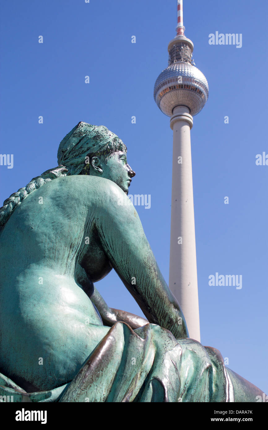 L'une des statues de la Neptunbrunnen ensemble avec la Fernsehturm (tour de télévision) en arrière-plan Mitte Berlin Allemagne Banque D'Images