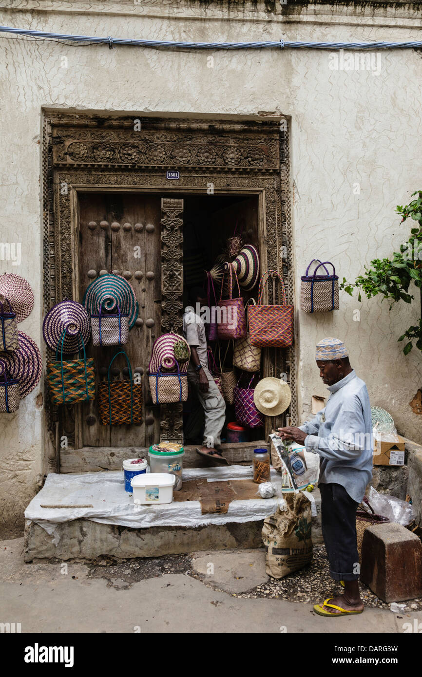 L'Afrique, Tanzanie, Zanzibar, Stone Town. L'homme assis à bord de la boutique. Banque D'Images