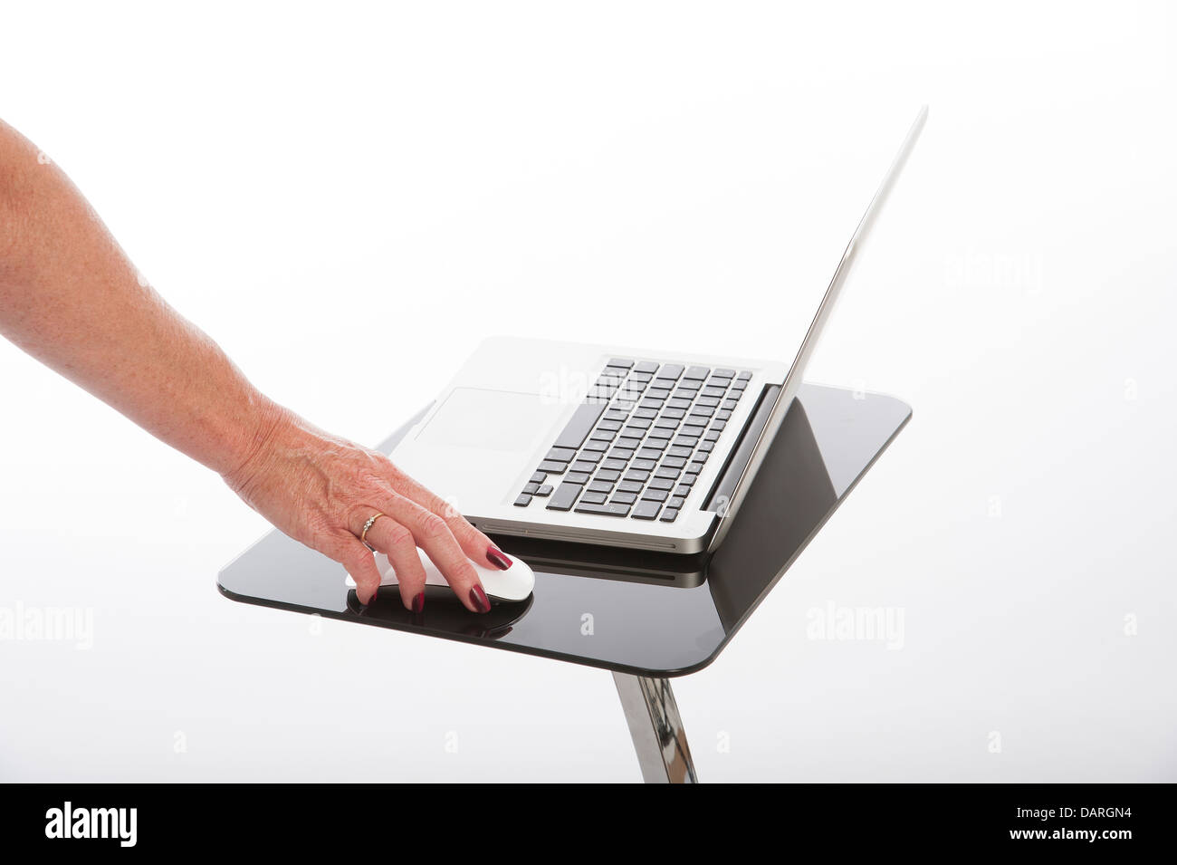 Femme à l'aide d'un ordinateur portable sur une table en verre noir Banque D'Images