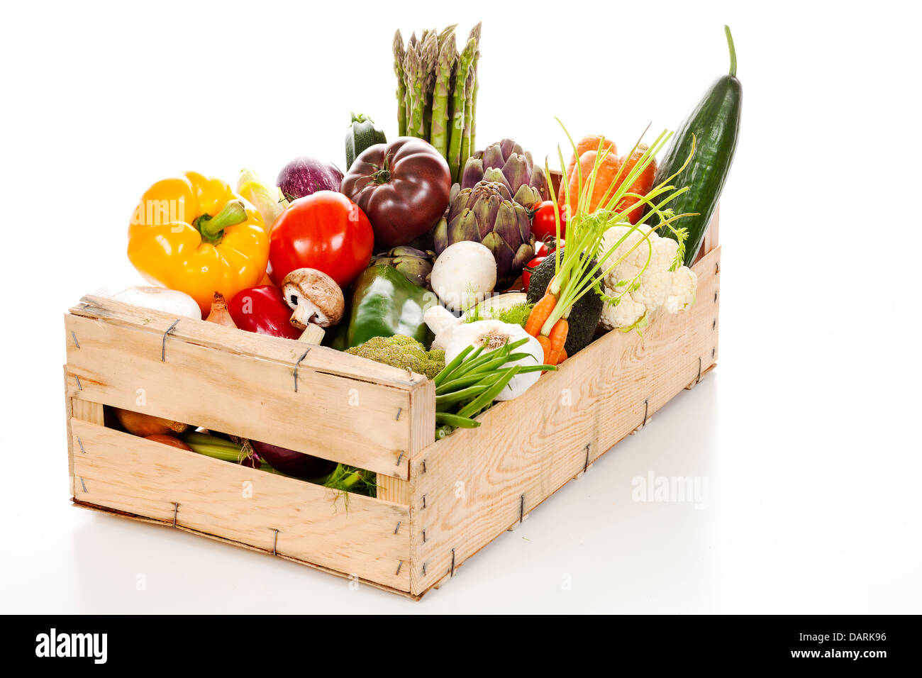 Assortiment de légumes frais dans une caisse sur fond blanc Banque D'Images