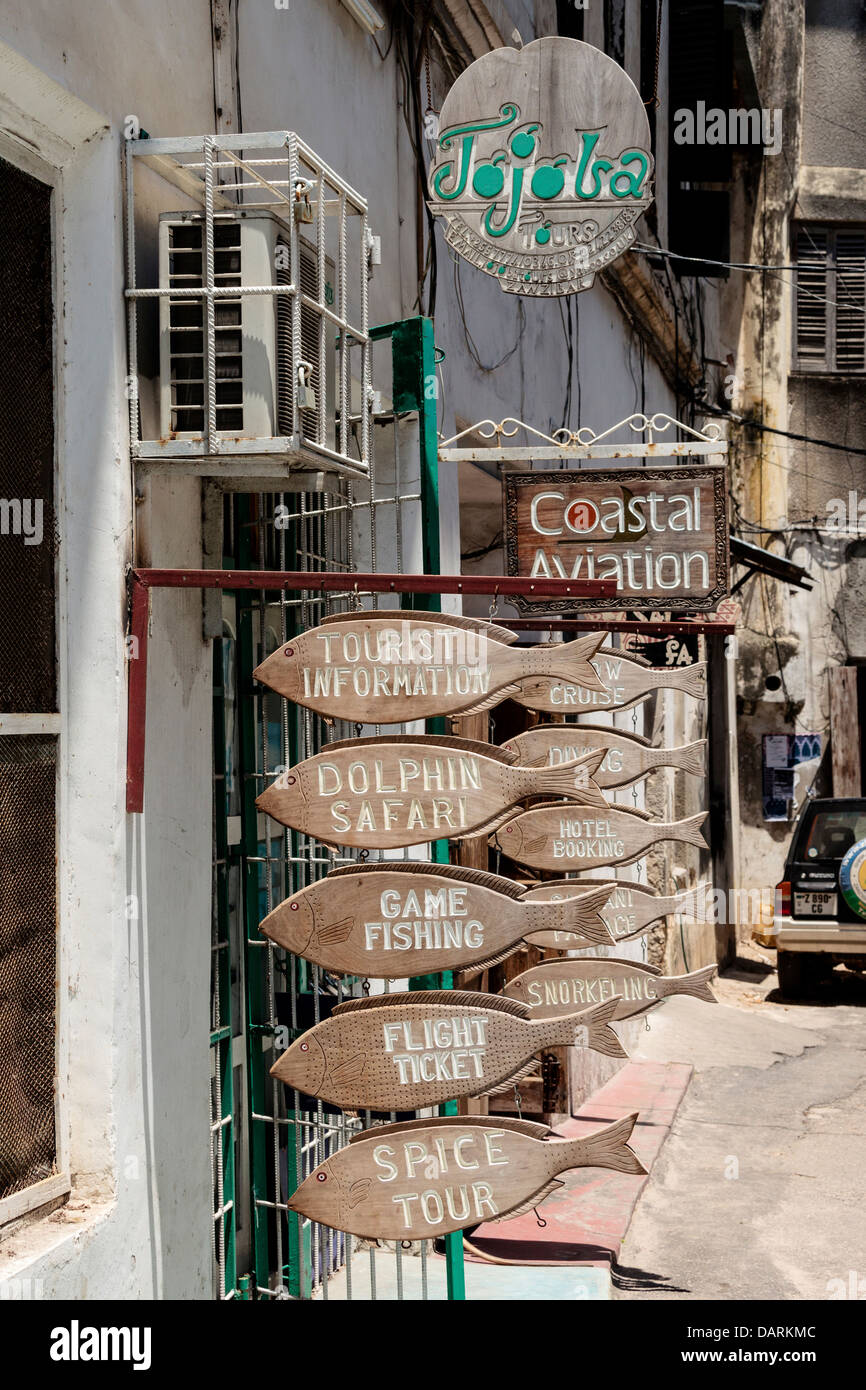 L'Afrique, Tanzanie, Zanzibar, Stone Town. Panneau en bois sur la publicité de la rue des activités touristiques. Banque D'Images