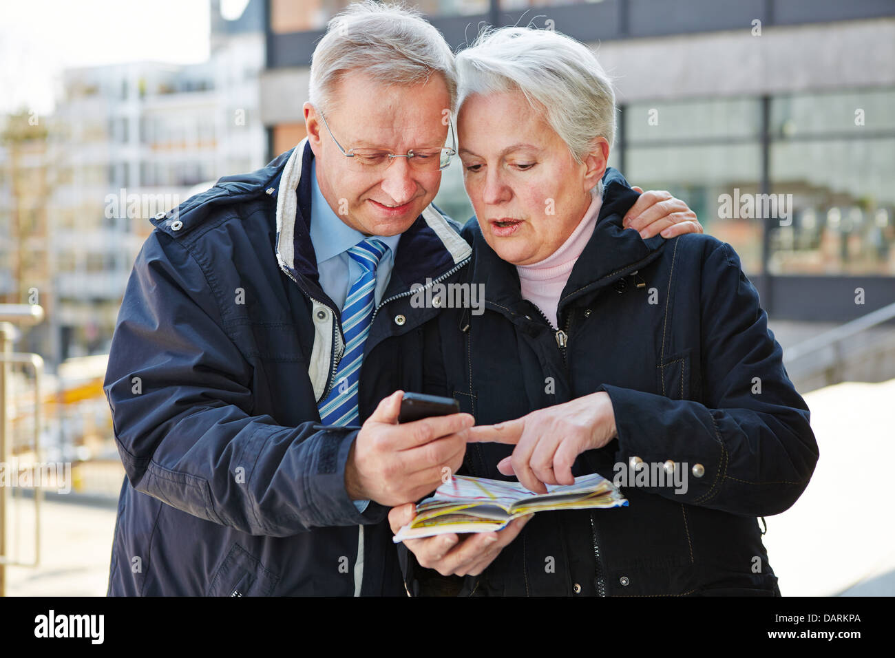 Couple de touristes avec la carte et smartphone dans une ville Banque D'Images
