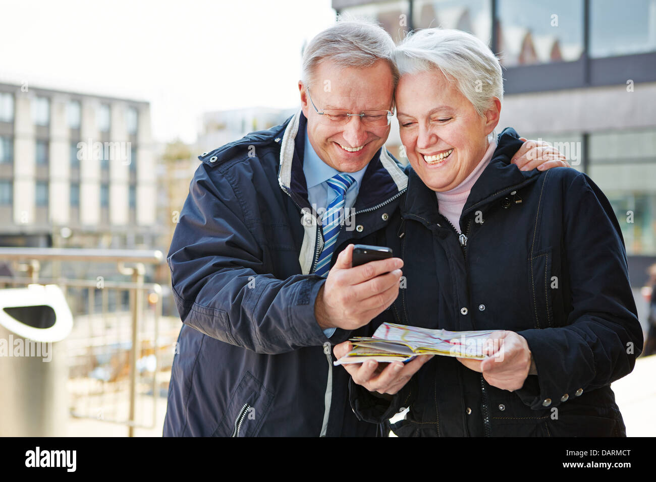 Happy senior couple with map et city guide app sur smartphone Banque D'Images