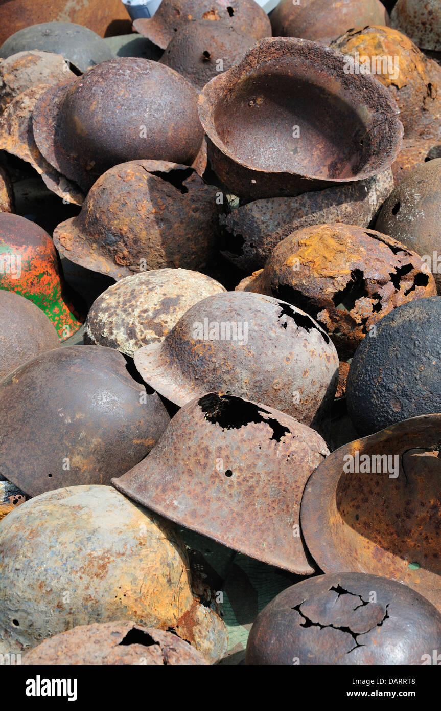 Old rusty casques d'acier allemand dans une pile. Reprise de la guerre et de la paix, juillet 2013. Hippodrome de Folkestone, Kent, Angleterre, Royaume-Uni. Banque D'Images