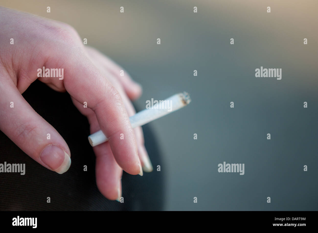 Un gros plan d'une mise au point sélective caucasian woman's hand holding a cigarette. Banque D'Images