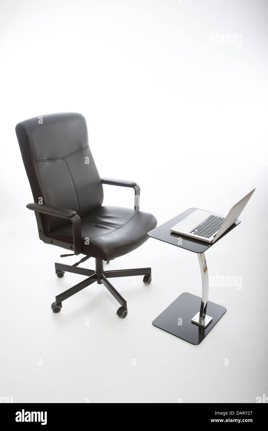 Chaise de bureau noir et ordinateur portable sur bureau en verre Banque D'Images