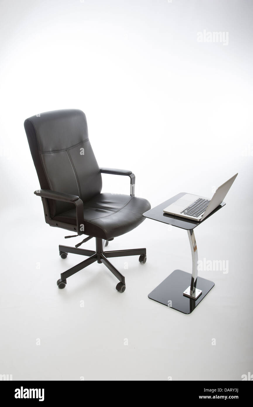 Chaise de bureau noir et ordinateur portable sur bureau en verre Banque D'Images