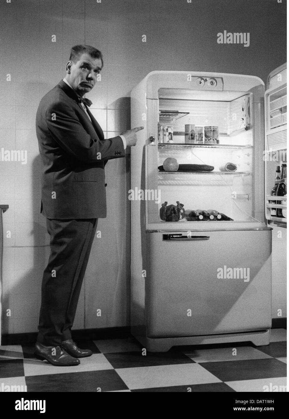Maison, cuisine et ustensiles de cuisine, réfrigérateur, homme impressionné pointant vers réfrigérateur ouvert avec contenu, années 1950, droits supplémentaires-Clearences-non disponible Banque D'Images