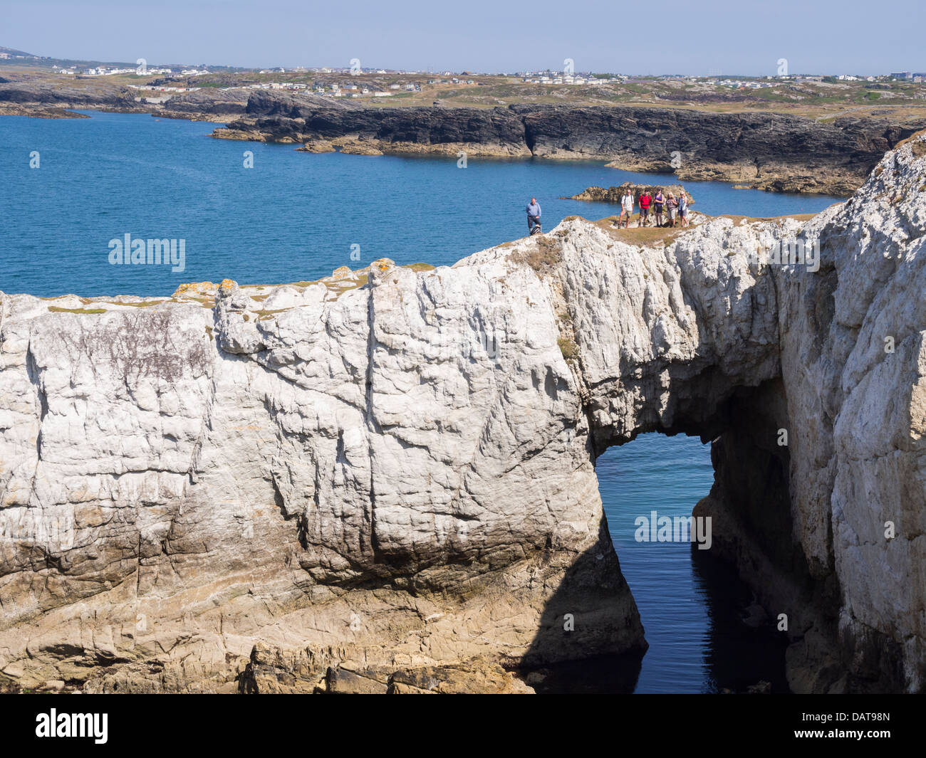 Groupe de randonneurs sur Bwa Gwyn ou quartzite naturel blanc Arch Rock formation sur l'île d'Anglesey Coastal Path Rhoscolyn Anglesey Pays de Galles Royaume-uni Grande-Bretagne Banque D'Images