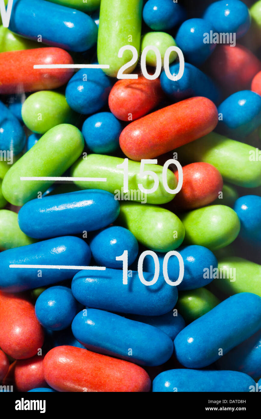 Close-up of pills drogues couleur dans le récipient en verre transparent Banque D'Images