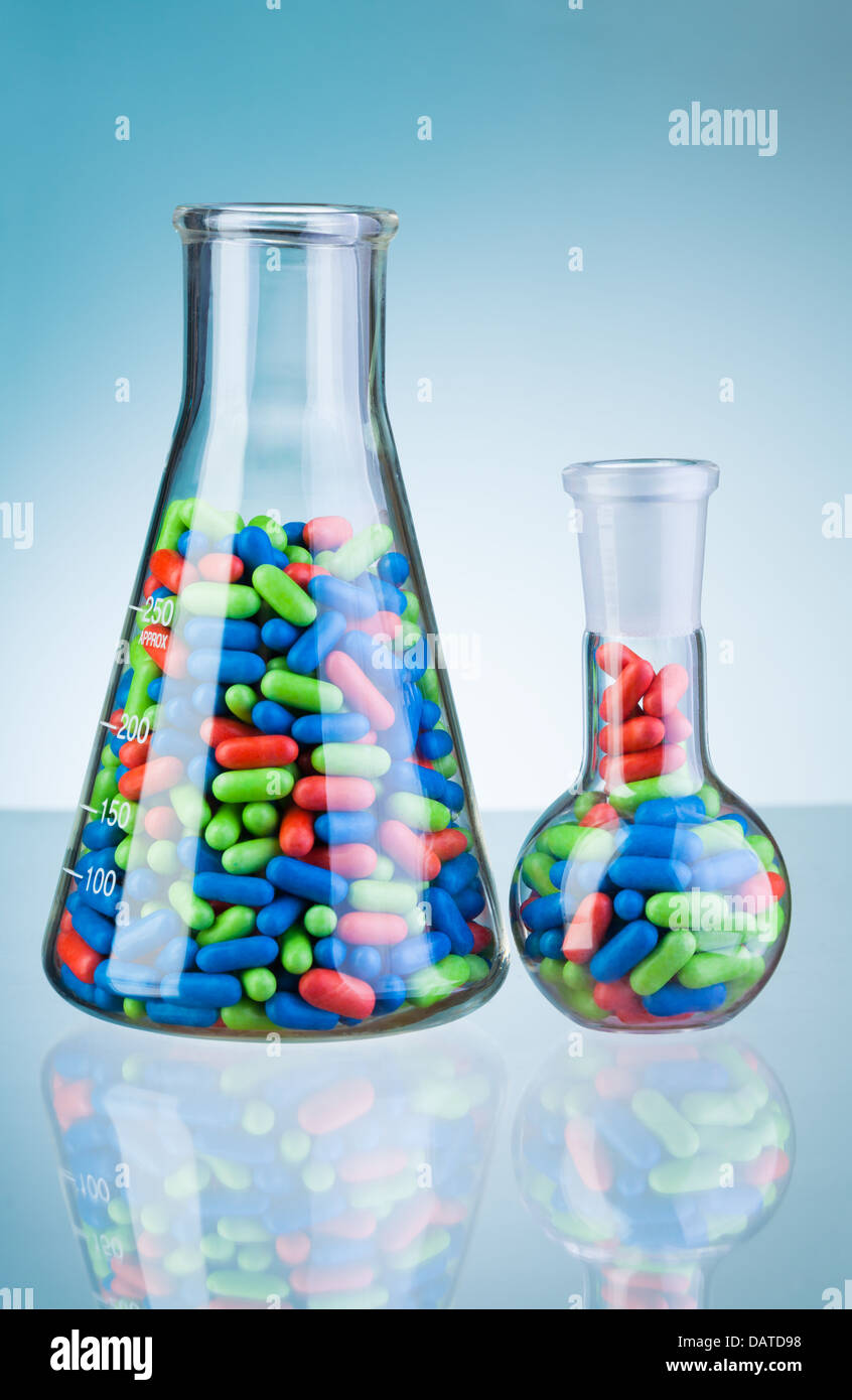 Autre vert bleu et rouge tablet comprimés médicaments dans deux flacons en verre de laboratoire Banque D'Images