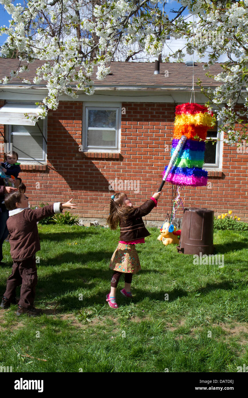 Les enfants frapper une piñata, lors d'une fête d'anniversaire de childs hispanique à Boise, Idaho, USA. Banque D'Images