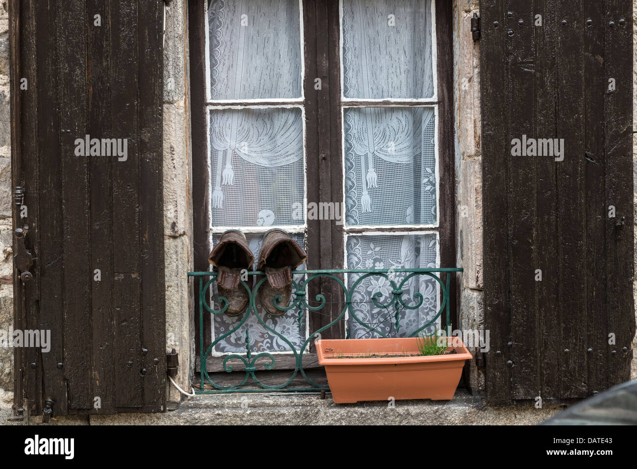 Une vieille paire de bottes en cuir accrochée à une fenêtre avant de sécher Banque D'Images
