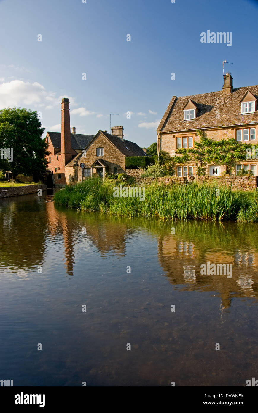 Les chalets et l'ancien moulin à eau dans la région de Lower Slaughter reflète dans l'Œil de la rivière dans le village des Cotswolds. Banque D'Images