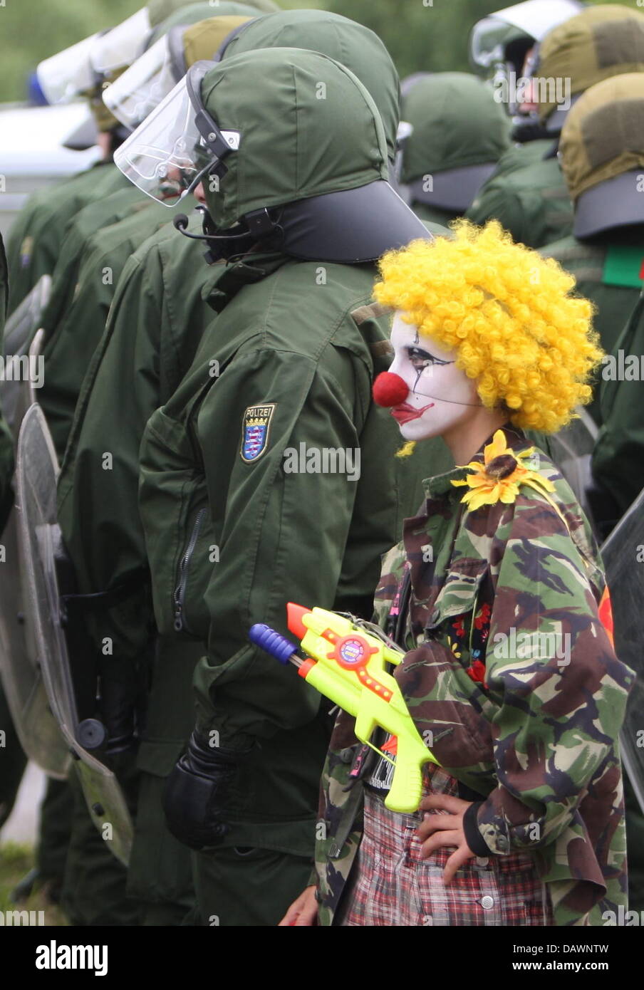 Un G8 manifestant habillé en clown se trouve à côté de la police anti-émeute du personnel lors d'un rassemblement à l'occasion de 'Migration' Journée à Rostock, Allemagne, 4 juin 2007. Le Sommet du G8 aura lieu à Heiligendamm du 06 au 08 juin. Photo : Kay Nietfeld Banque D'Images
