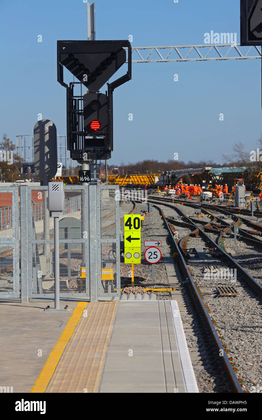 Nouveau chemin de signal sur la fin de la nouvelle plate-forme de la station avec les travailleurs de l'arrière-plan montrant également un ensemble de points de croisement. Banque D'Images