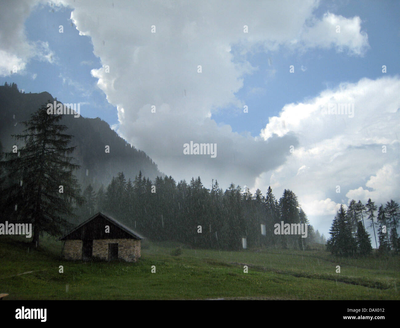 Une pluie d'été douche coule vers le bas sur une pente de montagne et d'une hutte près de Alpbach, Autriche, 8 juin 2007. Photo : Stephan Jansen Banque D'Images