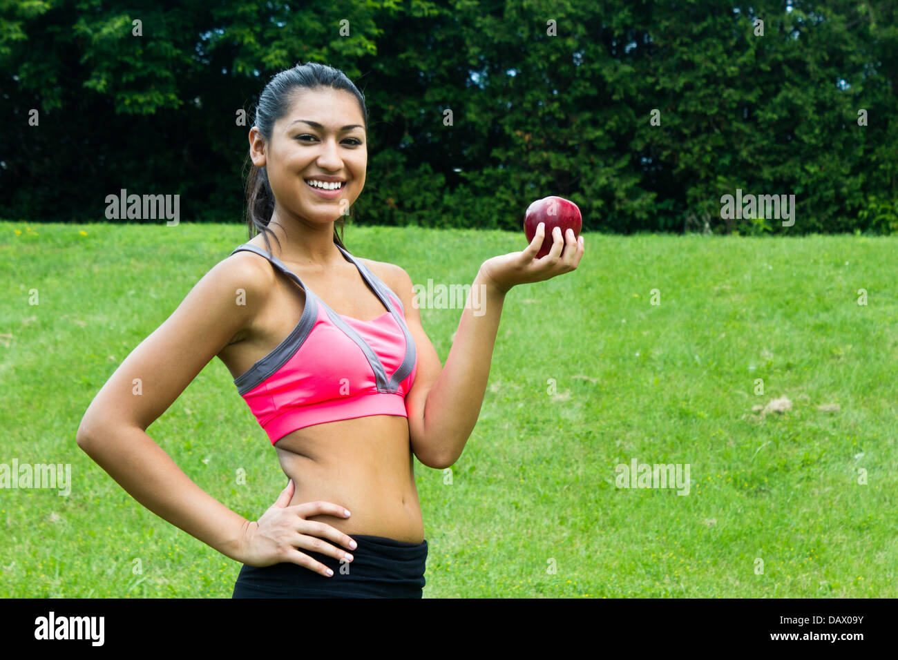Fit young woman with an apple in the park Banque D'Images