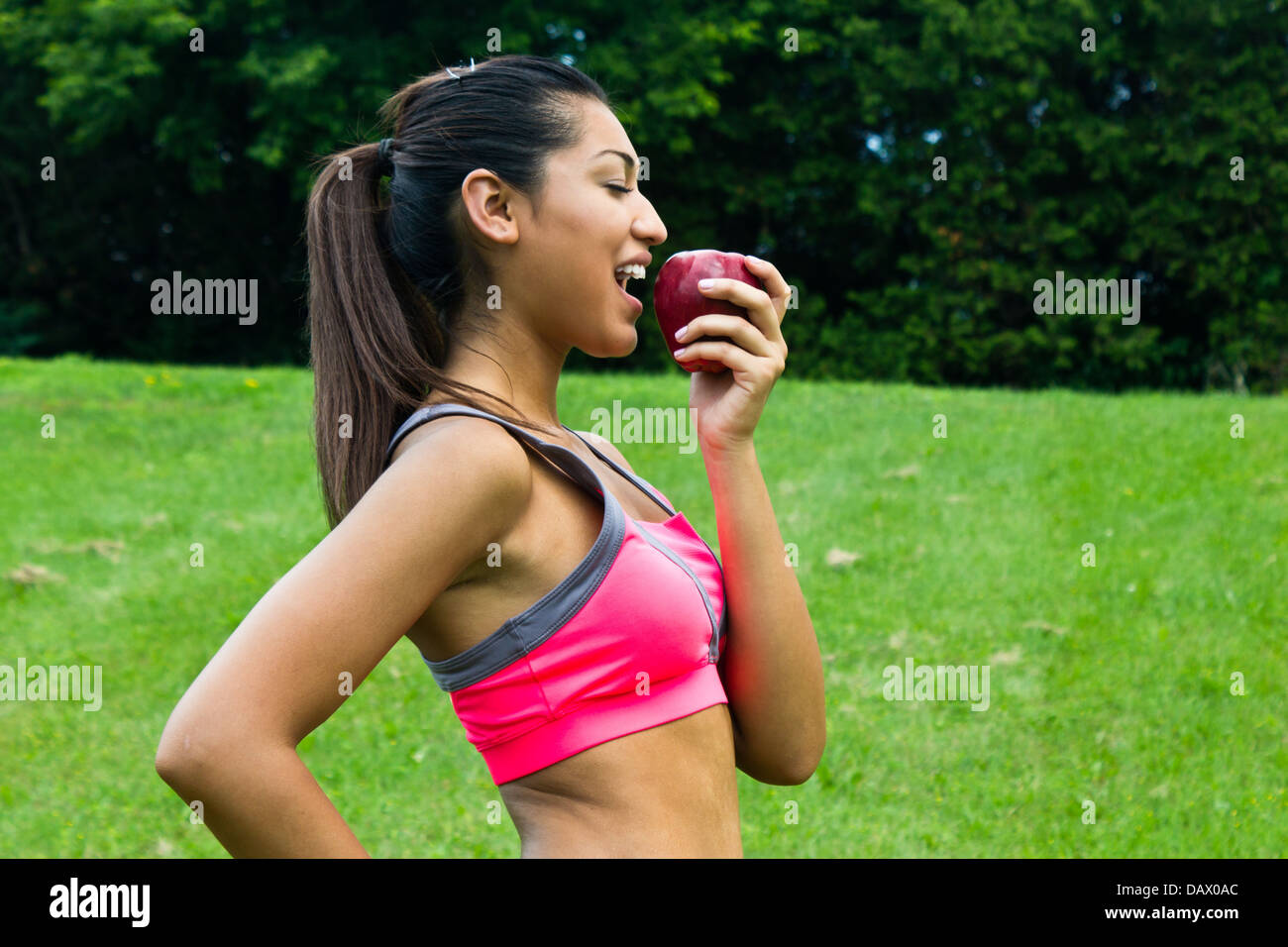 Fit young woman eating an apple Banque D'Images