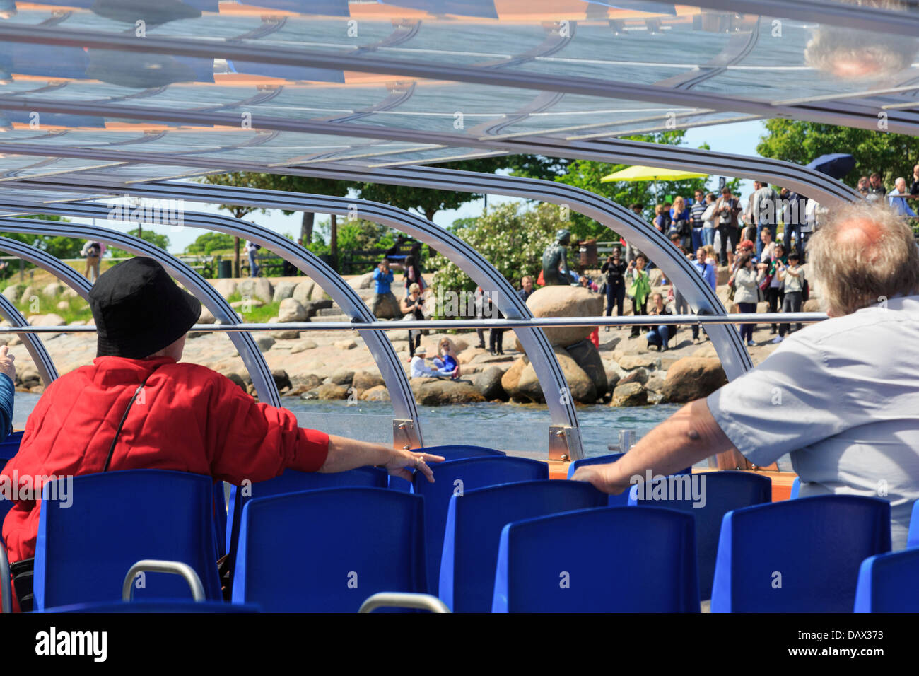 Les touristes sur un bateau à la tour à la statue de la Petite Sirène au bord de l'eau à Copenhague, Danemark Banque D'Images