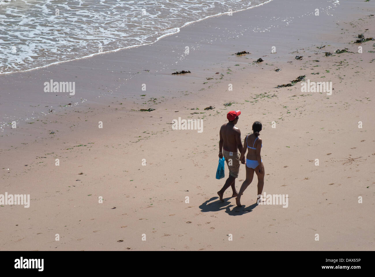 Broadstairs, Kent, Angleterre. Jeune couple en train de marcher sur la plage à Louisa Bay Banque D'Images