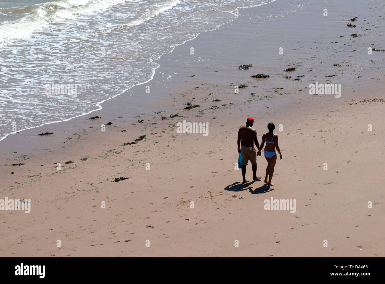 Broadstairs, Kent, Angleterre. Jeune couple en train de marcher sur la plage à Louisa Bay Banque D'Images