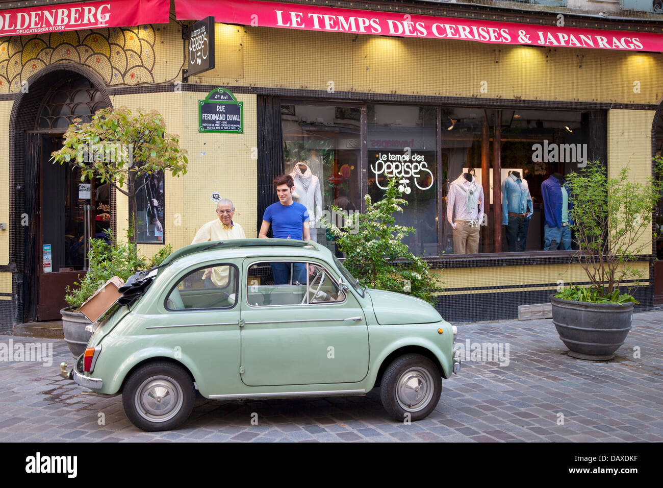 Deux hommes admirer une fiat verte garée dans le quartier du Marais, Paris France Banque D'Images