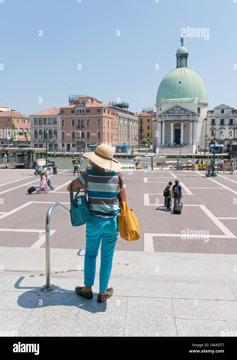 Femme au chapeau de paille se dégage de la gare Santa Lucia de Venise et voit le Grand Canal et l'église de San Simeon Piccolo Banque D'Images