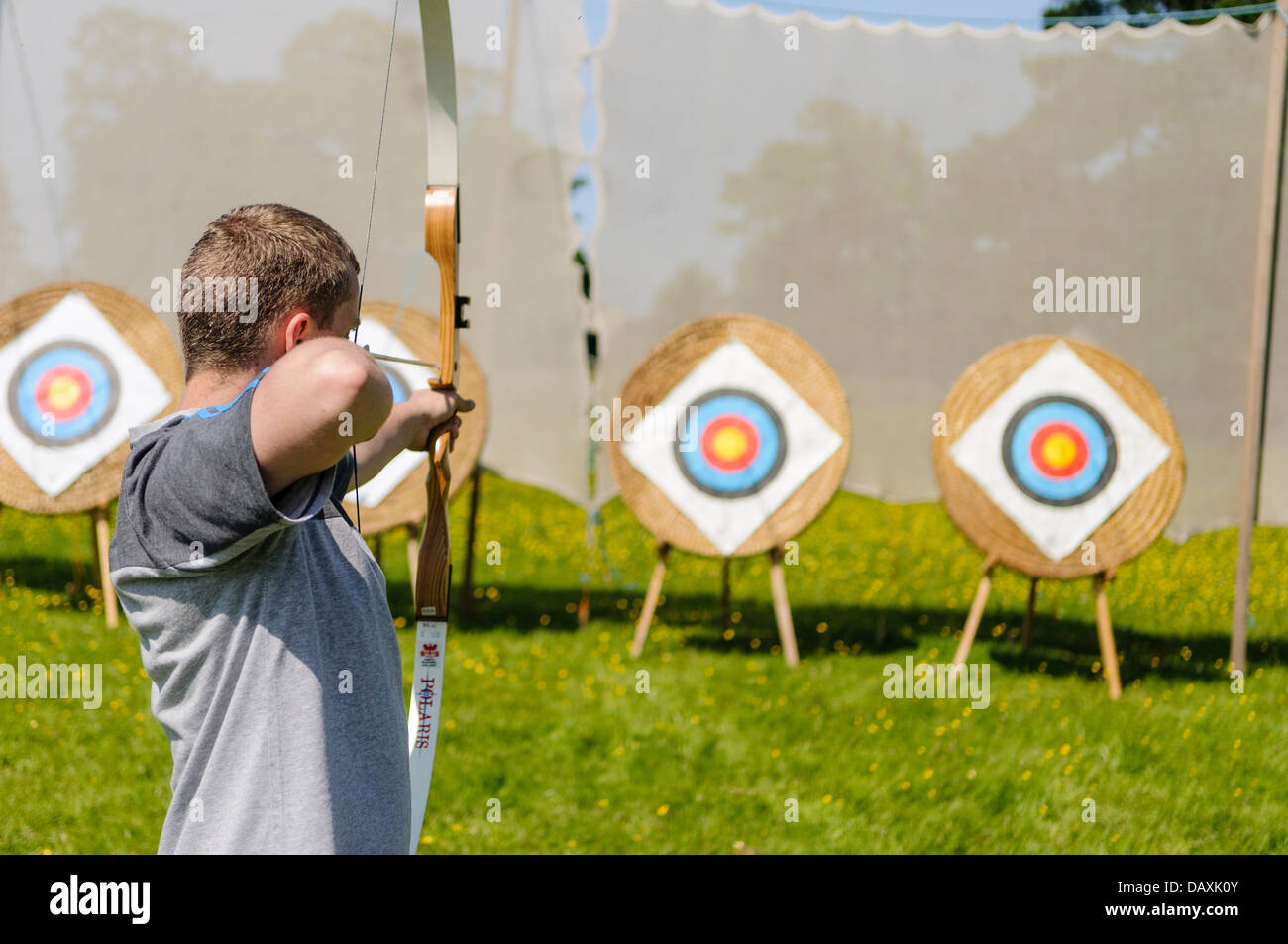 Un homme vise une flèche sur une cible de tir à l'ARC Banque D'Images