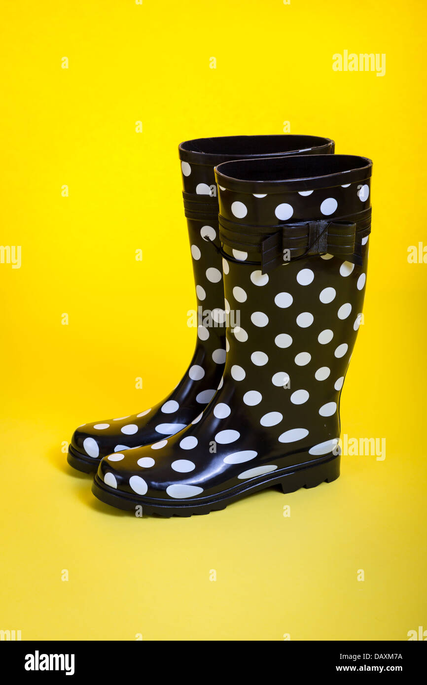 Une paire de bottes en caoutchouc à pois sur un fond jaune Photo Stock -  Alamy