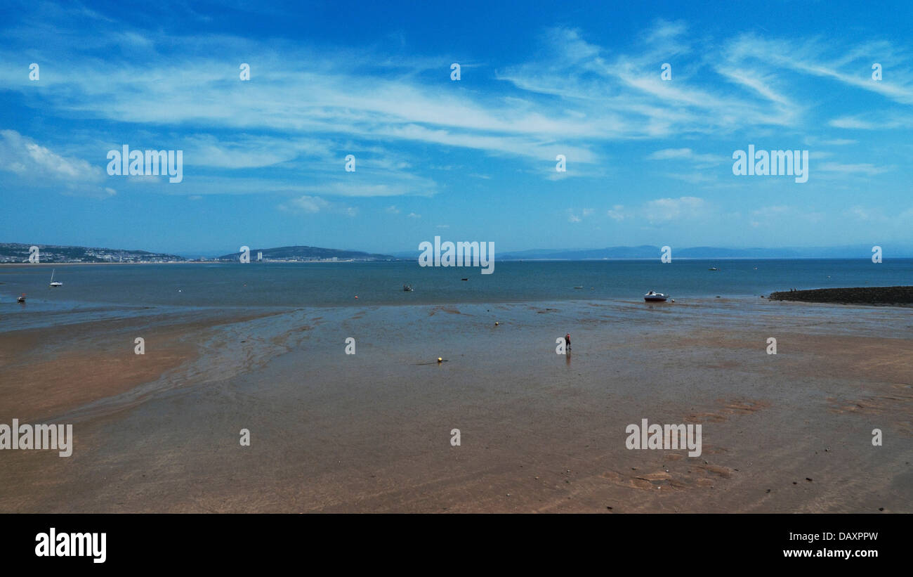 Personne qui marche sur le sable à marée basse avec bateaux ciel dramatique et vue sur la Baie de Swansea de Mumbles plage à marée basse en été Wales UK KATHY DEWITT Banque D'Images