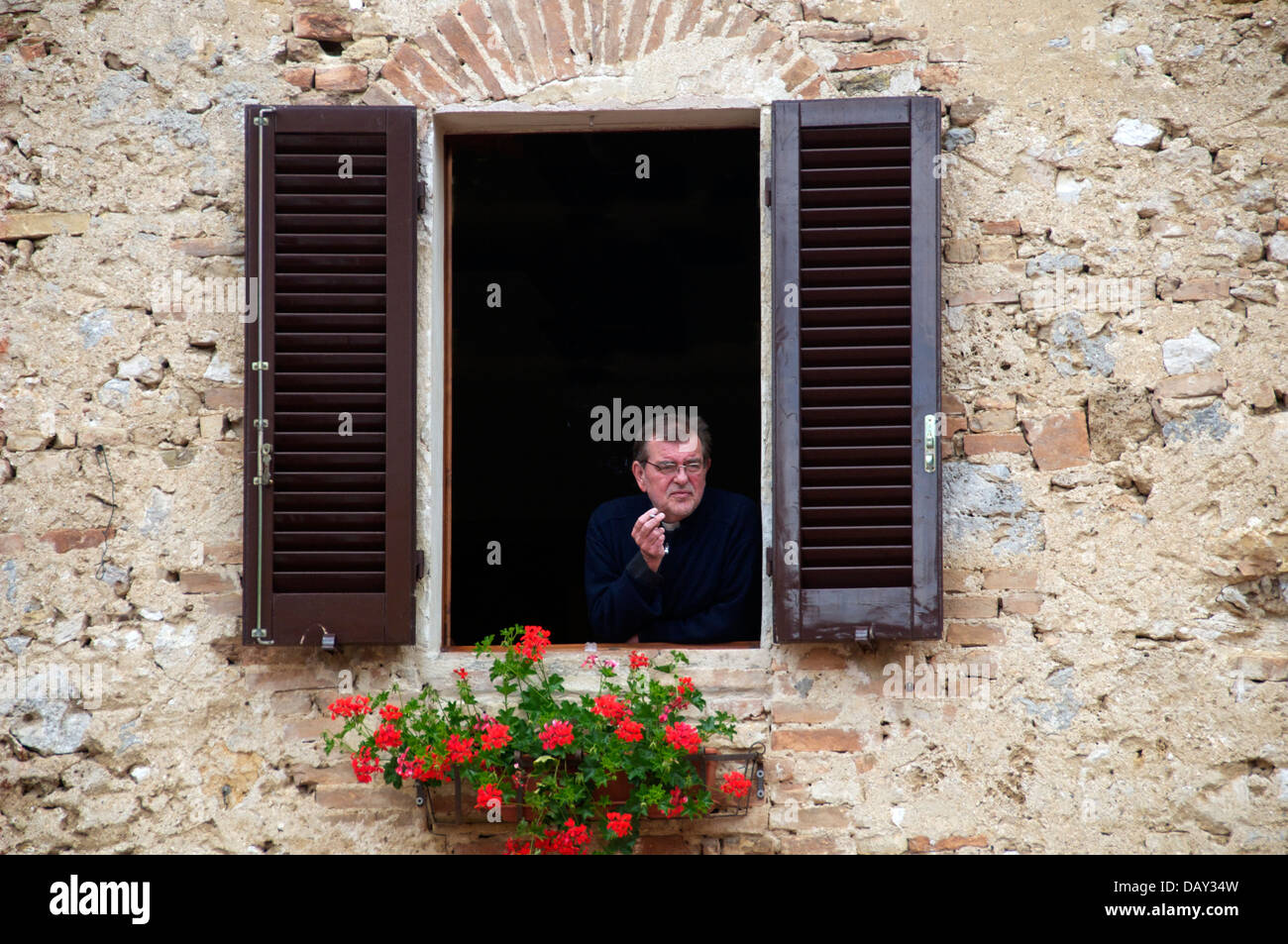 Cigarette prêtre dans la fenêtre encadrée San Gimignano Toscane Italie Banque D'Images