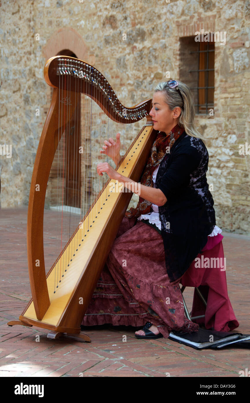 Femme jouant de la harpe à courtyard San Gimignano Toscane Italie Banque D'Images