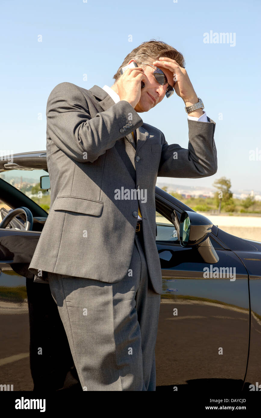 Businessman with cellphone près de la voiture Banque D'Images