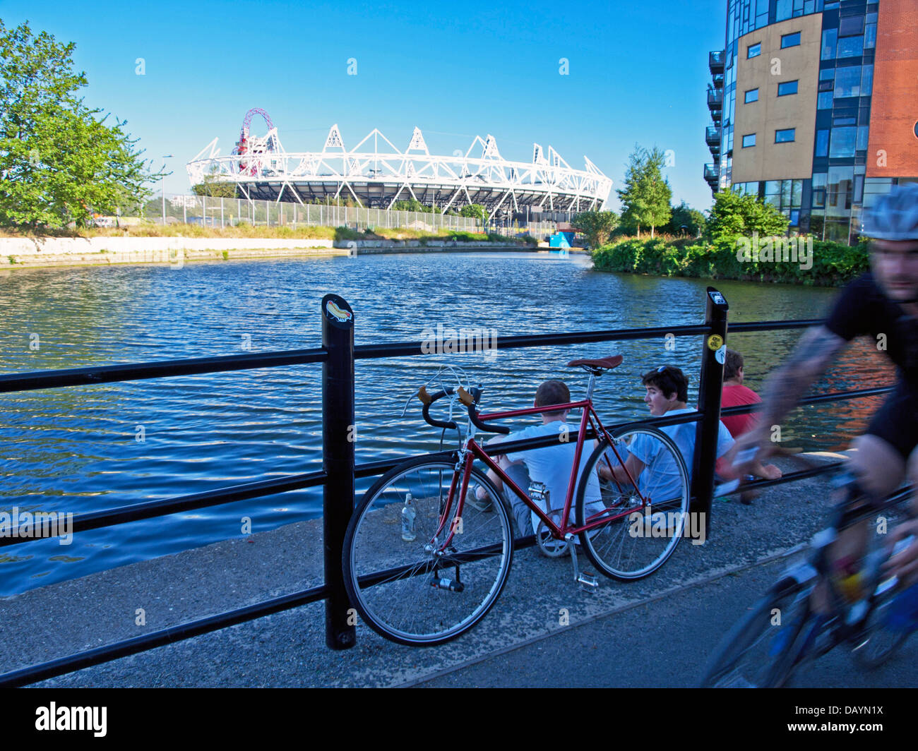 Homme randonnée à vélo le long de la rivière Lea (Lee) la navigation, Hackney Wick montrant le Stade Olympique et ArcelorMittal Orbit à distance Banque D'Images