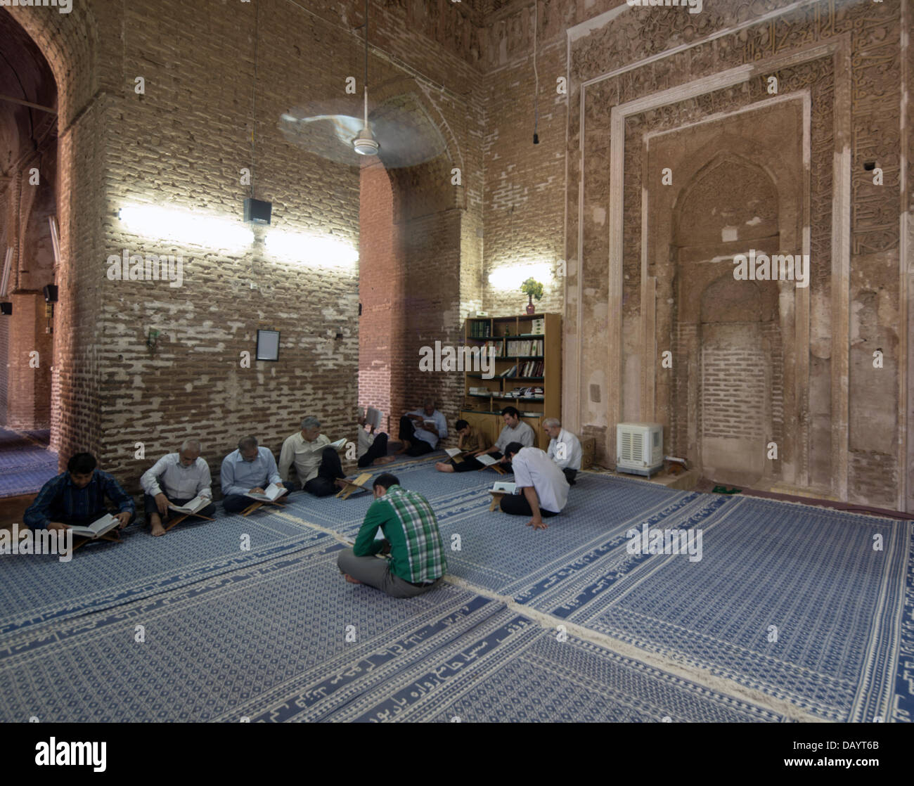 Les musulmans dans l'attente de l'iftar rupture du jeûne du Ramadan lire le Coran dans la vieille mosquée dans le village de Zavareh, Iran Banque D'Images