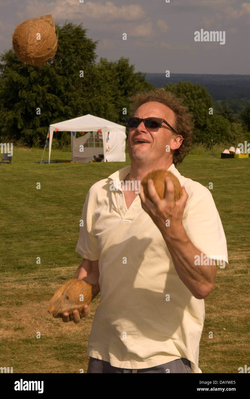 Man juggling coco à Worldham Fête du Village, Hampshire, Royaume-Uni. Dimanche 14 juillet 2013. Banque D'Images