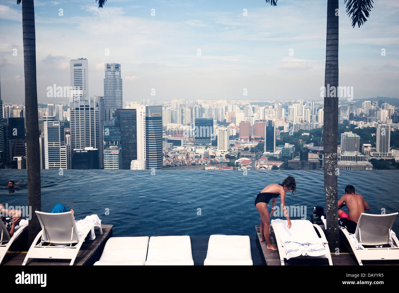 Les clients de l'hôtel bénéficiant d'horizon de la ville de Singapour par le Marina Bay Sand infinity pool deck Banque D'Images