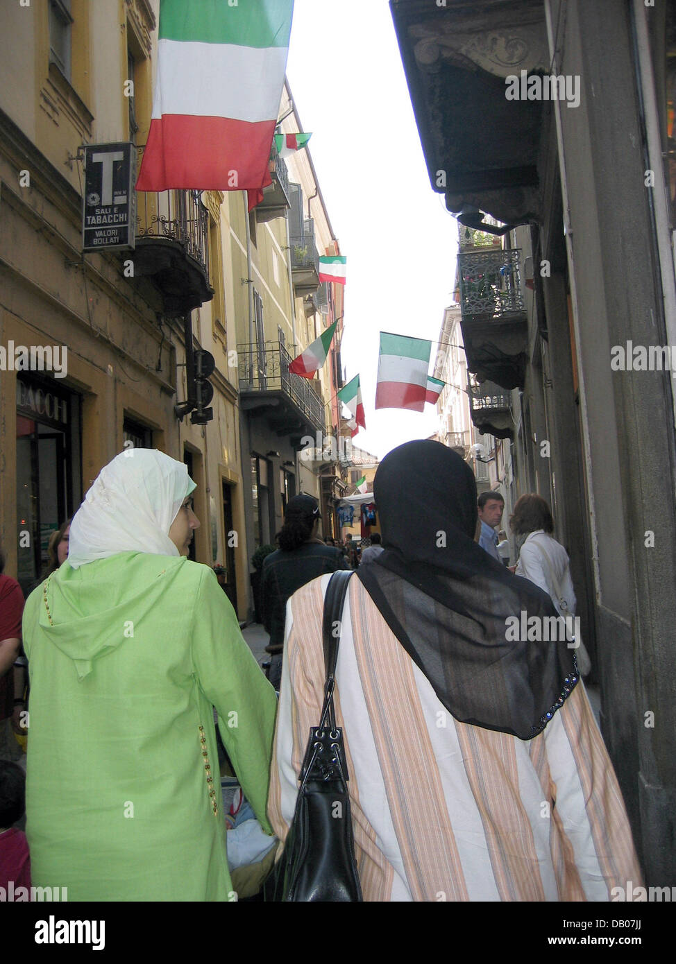 Deux femmes musulmanes portant des foulards de tête à pied par une allée  décorée avec un drapeau italien à Alba, Italie, 26 avril 2007. Photo : Rolf  Haid Photo Stock - Alamy