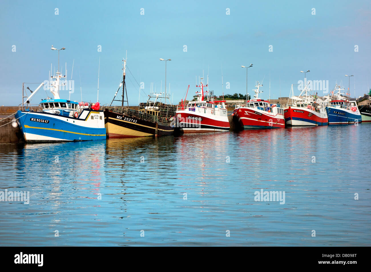 Une ligne de bateaux de pêche une marée basse le long du mur du port de Roscoff Banque D'Images