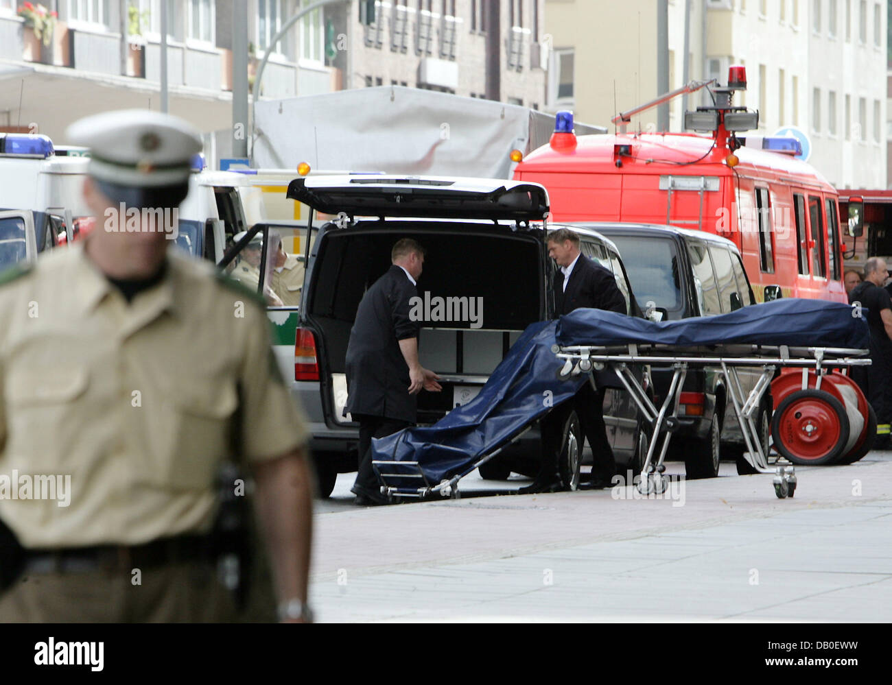 Pompes funèbres transports deux corps dans des sacs mortuaires à partir de  la scène du crime à un corbillard à la gare centrale à Duisburg, Allemagne,  15 août 2007. Six hommes qui