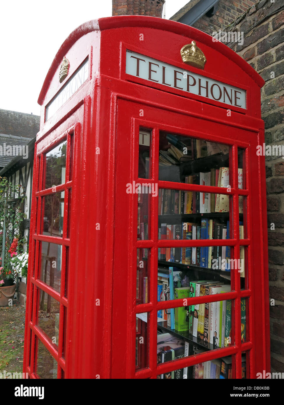 Un vieux téléphone britannique rouge fort transformé en un village britannique bibliothèque excentrique Banque D'Images