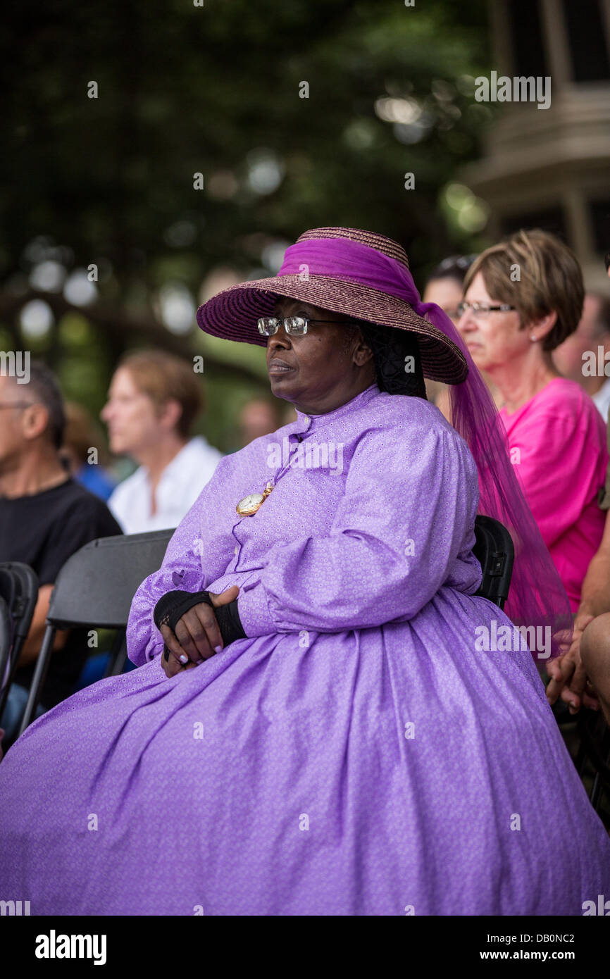 Une femme habillé en costume de guerre civile à l'écoute au cours d'une cérémonie dévoilant un mémorial en hommage à la 54e sur le 150e anniversaire de l'assaut sur la batterie Wagner le 21 juillet 2013 à Charleston, SC. La bataille oubliée dans le film 'gloire' a eu lieu à Charleston et a été la première grande bataille d'un régiment noir. Banque D'Images