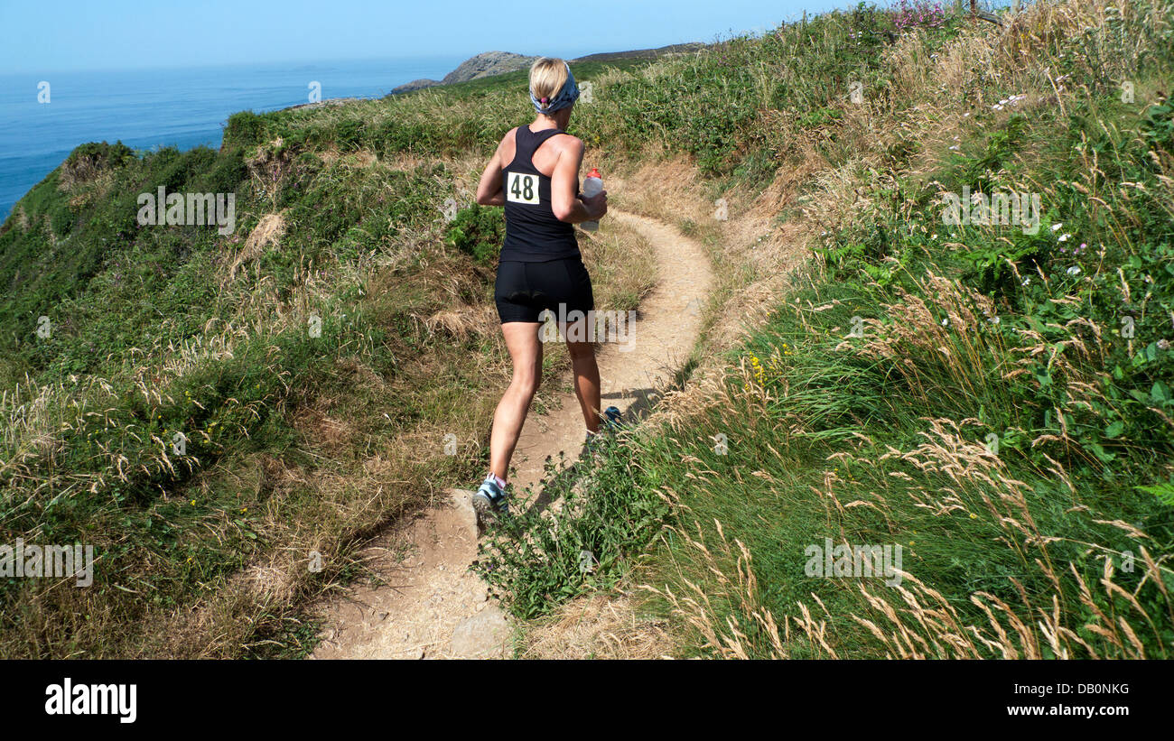 Concurrent d'exécution sur le chemin de la côte du Pembrokeshire, dans la course sur 2013 Whitesands Triathlon St David's Head Wales UK Banque D'Images