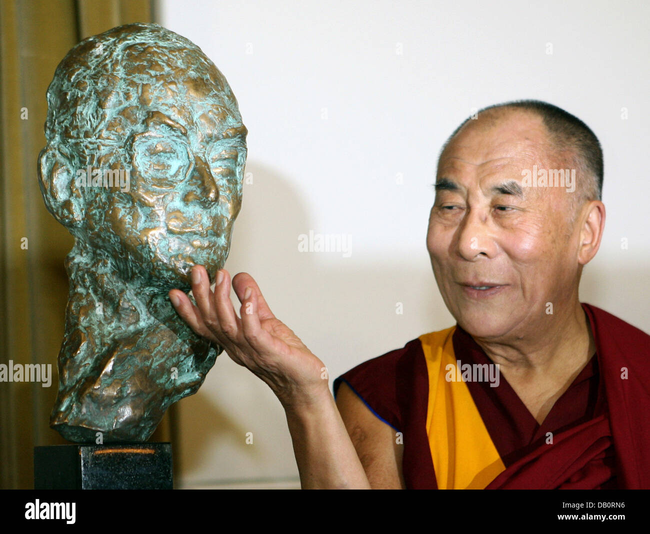Le dalaï-Lama touche un buste représentant lui-même sur le menton à l'auditorium de l'Université de Münster, Allemagne, 20 septembre 2007. Le leader tibétain sera décerné un doctorat honorifique de l'université des sciences naturelles du ministère et par la suite signer le livre d'or de la ville. La lauréate du Prix Nobel de la paix, rencontrera la chancelière allemande Angela Merkel pour un "échange d'idées" à Berlin, Banque D'Images