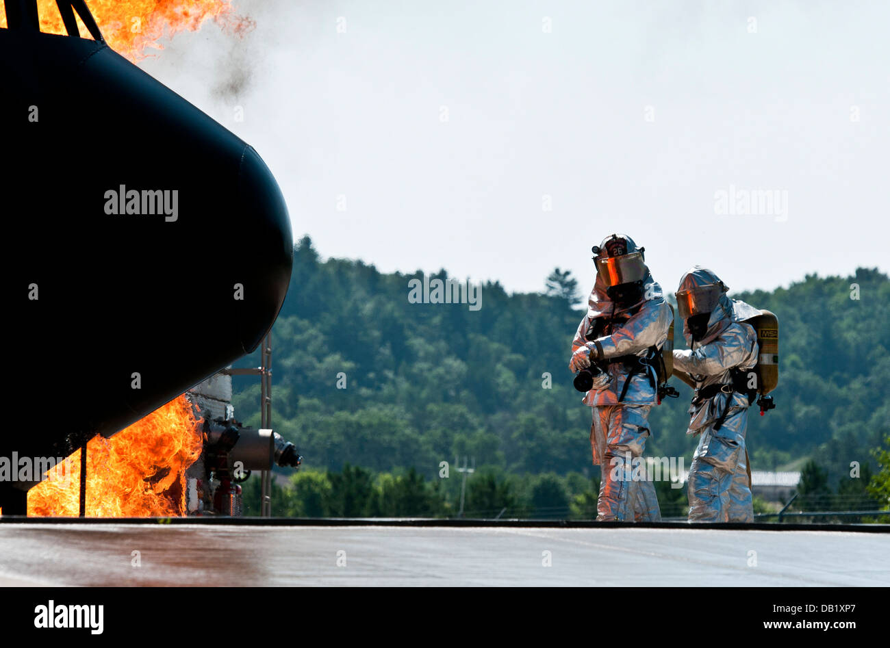 Deux gardes nationaux de l'air d'attendre un ordre d'éteindre un incendie à Volk Field la préparation au combat au Centre à Camp Douglas, Wisconsin, le 18 juillet 2013, lors de l'exercice Patriot 13. La Patriot l'exercice est un scénario d'opérations nationales pour évaluer la Gomme Guar Banque D'Images